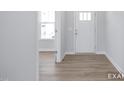 Clean entryway with light wood floors, white walls, and a front door with glass panels at 436 Longleaf Glen Lane, Zebulon, NC 27597