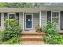 Inviting front entrance with brick steps, a dark-colored door, and well-maintained landscaping at 5002 Kendridge Dr, Durham, NC 27712