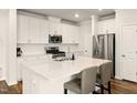 Bright kitchen with stainless steel appliances, white cabinets, and a large center island with bar seating at 501 Hazy Hills Ln, Garner, NC 27529