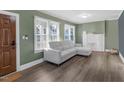 Bright living room with modern gray sofa, decorative fireplace, hardwood floors and natural light from large windows at 507 S Mebane St, Burlington, NC 27215