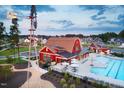 Stunning aerial view of community with pool, windmill, and red barn style clubhouse in beautiful neighborhood at 62 Restful Point, Fuquay Varina, NC 27526