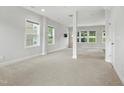 Spacious carpeted basement with natural light from multiple windows and a support column at 635 Black Angus Dr, Haw River, NC 27258