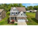 Charming two-story home featuring stone accents, a two-car garage, and manicured lawn at 635 Black Angus Dr, Haw River, NC 27258