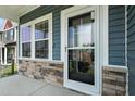 Inviting front porch with stone accents and a storm door with sidelight windows at 635 Black Angus Dr, Haw River, NC 27258