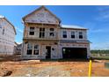 Exterior view of new construction with a covered porch and two-car garage at 682 Old Station Pointe, Angier, NC 27501