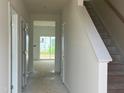 Hallway featuring clean lines, neutral paint, and natural light showcasing the staircase and open floorplan at 682 Old Station Pointe, Angier, NC 27501