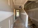 Unfinished hallway with visible staircase and natural light streaming from the end windows at 682 Old Station Pointe, Angier, NC 27501