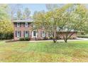 Traditional brick home with well-manicured lawn and mature trees at 6824 Branton Dr, Cary, NC 27519