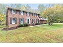 Traditional brick home with shutters, a manicured lawn, and mature trees at 6824 Branton Dr, Cary, NC 27519