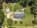 Aerial view of home on a large lot, featuring a detached garage, garden, and mature trees at 921 Sweet Raspberry Lane Ln, Lillington, NC 27546