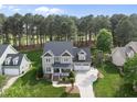 An elevated view of a beautiful two-story home with an attached garage, lush green lawns and mature trees at 925 Hidden Jewel Ln, Wake Forest, NC 27587