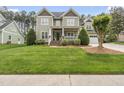Charming home featuring a welcoming front porch, lush green lawn, and mature landscaping at 925 Hidden Jewel Ln, Wake Forest, NC 27587