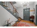 Bright foyer features a staircase, modern light fixture and hardwood floors and rug at 925 S Chestnut St, Henderson, NC 27536
