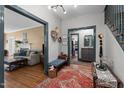 Open-concept foyer with wood floors leading to a living room and kitchen and a staircase at 925 S Chestnut St, Henderson, NC 27536