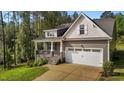 Charming home featuring stone accents, a covered front porch, and an attached two-car garage at 96 Linda Lou Ln, Angier, NC 27501