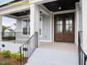 Inviting entryway with a covered porch, showcasing a stylish front door, sturdy railing, and meticulous landscaping at 1036 Smoke Willow Way, Rolesville, NC 27571