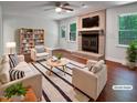 Bright living room boasts a brick fireplace, ceiling fan, and modern furniture at 1104 Theresa Ct, Raleigh, NC 27615