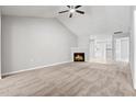 Spacious living room boasting a vaulted ceiling, ceiling fan, cozy fireplace, and neutral carpet at 11220 Avocet Ln # 104, Raleigh, NC 27617
