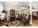 Elegant sitting room with hardwood floors, crown molding, and an eclectic design at 115 Thornwhistle Pl, Garner, NC 27529