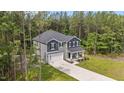 An aerial view showcases a two-story home with an attached garage surrounded by lush greenery and tall trees at 120 Rocking Horse Ln, Sanford, NC 27332