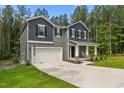 Charming two-story home with a covered front porch, a two-car garage, and a well-manicured lawn at 120 Rocking Horse Ln, Sanford, NC 27332
