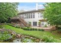 Back exterior showing the backyard of this amazing house and its beautiful deck overlooking a pond with a water feature at 12212 Ashton Woods Ln, Raleigh, NC 27614