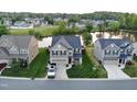 Aerial view of home with manicured lawn and tranquil pond in a peaceful neighborhood setting at 123 Claystone Dr, Gibsonville, NC 27249