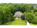 Aerial view of a stunning home nestled among lush, mature trees and manicured lawn at 1308 Woodgate Manor Ct, Raleigh, NC 27614