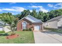 Inviting brick home with well-maintained lawn and a paved driveway leading to the garage at 133 Marino Pl, Clayton, NC 27527