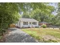 Charming single-story home with a light blue door, brick steps, and a cozy front yard seating area at 1408 Ida St, Durham, NC 27705