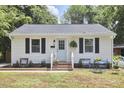 Charming single-story home with a light blue door, brick steps, and a cozy front yard seating area at 1408 Ida St, Durham, NC 27705