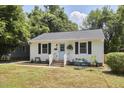 Charming single-story home with a light blue door, brick steps, and a cozy front yard seating area at 1408 Ida St, Durham, NC 27705