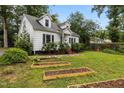 Charming Cape Cod-style house with dormers, garden beds, and a lush front lawn at 1541 Shadylawn Dr, Burlington, NC 27215