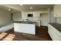 Bright kitchen boasting a central island, wooden floors, and ample cabinet space at 180 Tulipfield Way, Benson, NC 27504