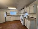 Traditional kitchen featuring white cabinets, laminate flooring, and ample counter space at 195 Washington Ln, Cameron, NC 28326