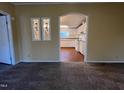 Living room view showcasing decorative windows with an archway leading to a kitchen with white cabinets at 195 Washington Ln, Cameron, NC 28326