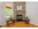 Cozy fireplace with stone surround, hardwood floors, and a large window at 200 Daniel Ridge Ln, Roxboro, NC 27574