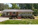 Charming single story home with red brick, grey siding, metal roof and manicured landscaping at 203 W Boundary St, Cary, NC 27513