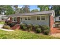 Charming home featuring red brick, grey siding, metal roof and manicured landscaping at 203 W Boundary St, Cary, NC 27513