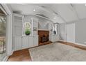 Cozy living room with a brick fireplace, built-in shelving, and hardwood floors at 203 W Boundary St, Cary, NC 27513