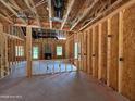 Unfinished living room showcasing framing, fireplace, and door to backyard in new construction at 209 Atkins Rd, Cameron, NC 28326