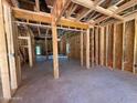 Spacious unfinished living room displaying framing, electrical wiring, and door to backyard at 209 Atkins Rd, Cameron, NC 28326