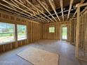 Unfinished living room with exposed framing, large windows, and an unfinished ceiling at 235 Atkins Rd, Cameron, NC 28326