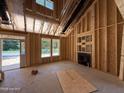 Unfinished living room with fireplace, exposed framing, and a side door to the exterior at 235 Atkins Rd, Cameron, NC 28326