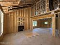 Unfinished living room showcasing exposed framing, a cozy fireplace, and natural light from the windows at 235 Atkins Rd, Cameron, NC 28326