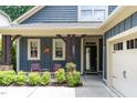 Charming front porch with blue siding, rustic wooden beams, and inviting pink chairs at 241 Serenity Hill Circle Cir, Chapel Hill, NC 27516
