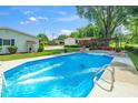 Inviting in-ground pool with lounge chairs, surrounded by a well-maintained yard and various outbuildings at 2925 Redwood Rd, Durham, NC 27704
