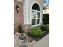 Beautifully landscaped yard featuring a large window, decorative brick, and vibrant plantings at 3129 Elm Tree Ln, Raleigh, NC 27614
