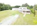 An exterior view of a multi-story home on a sunny day surrounded by green landscape at 3354 Altamahaw Church Rd, Elon, NC 27244