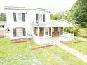 A cozy front porch with brick accents, white railing, and a well-manicured lawn at 3354 Altamahaw Church Rd, Elon, NC 27244